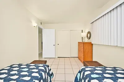 a bedroom with a bed and two chairs at Oceanfront Home on the Boardwalk with 3 car Garage, AC, Giant Patio, Ocean Views, Walk to Pier in Newport Beach