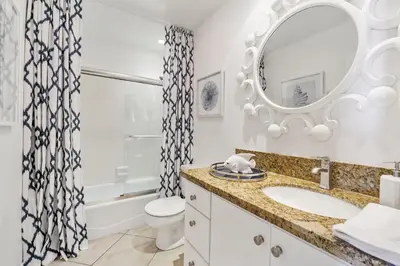a white bathroom with a sink and a mirror at 7 Bedroom Oceanfront Triplex Building in Newport Beach