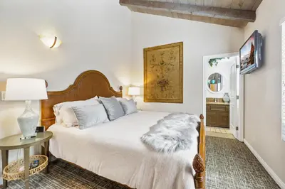 a bedroom with a bed and a table with a lamp at 7 Bedroom Oceanfront Triplex Building in Newport Beach