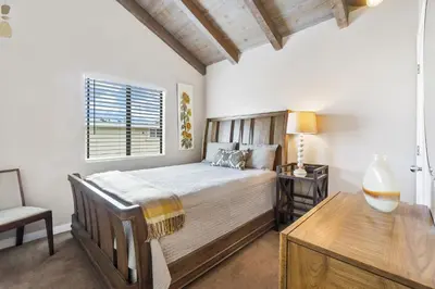 a bedroom with a bed and a desk and a window at 2 Bed 2 Bath BACK APT Steps to the Sand in Newport Beach
