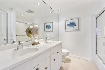 a white bathroom with two sinks and a toilet at 2 Bed 2 Bath BACK APT Steps to the Sand in Newport Beach