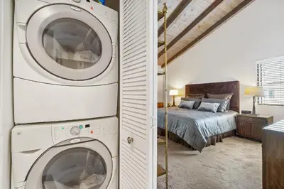 a bedroom with a washer and dryer next to a bed at 2 Bed 2 Bath BACK APT Steps to the Sand in Newport Beach