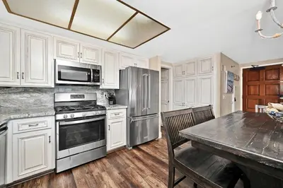 a kitchen with white cabinets and stainless steel appliances at Giant Beachfront Home with Parking near the Pier in Newport Beach