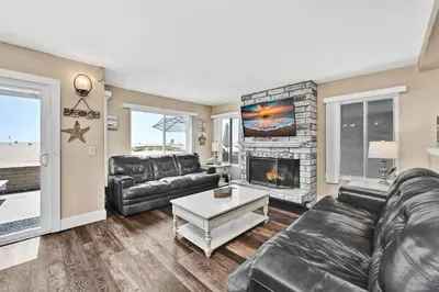 a living room with a couch and a fireplace at Giant Beachfront Home with Parking near the Pier in Newport Beach