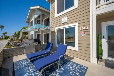 two chairs and an umbrella on the front of a house at Giant Beachfront Home with Parking near the Pier in Newport Beach