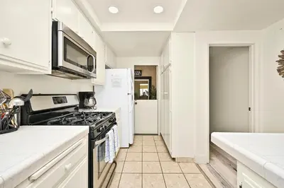 a kitchen with a stove and a microwave at Beachfront home with Sweeping Ocean Views, AC, Walk to the Pier, Restaurants, Shops, Activities in Newport Beach