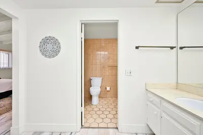 a white bathroom with a toilet and a sink at Beachfront home with Sweeping Ocean Views, AC, Walk to the Pier, Restaurants, Shops, Activities in Newport Beach