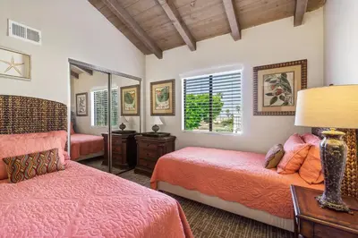 a bedroom with two beds and a mirror at 2 Homes Rented Together on the Oceanfront in Newport Beach