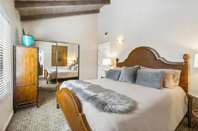 a bedroom with a large bed and a mirror at 2 Homes Rented Together on the Oceanfront in Newport Beach