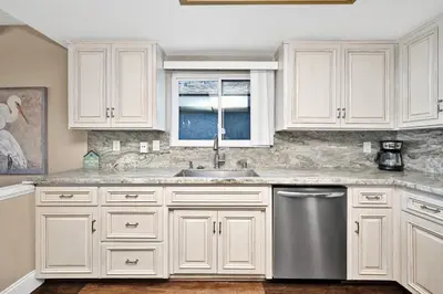 a kitchen with white cabinets and a stainless steel dishwasher at Stunning Oceanfront Retreat in Newport Beach in Newport Beach