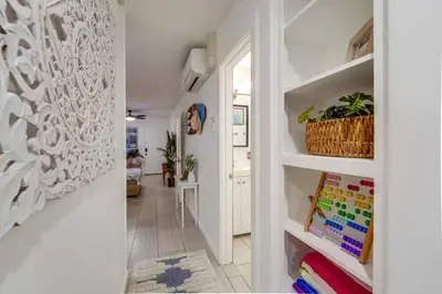 a hallway with white walls and white shelves with plants at Ocean View Blue Mission Beach Paradise in San Diego