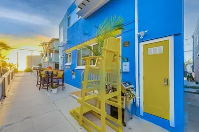 a blue building with a yellow door and a table and chairs at Ocean View Blue Mission Beach Paradise in San Diego