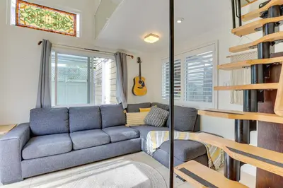 a living room with a blue couch and a guitar at Carlsbad Bungalow Patio, Hot Tub, Close to Beach! in Carlsbad