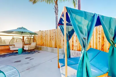 a patio with a tent and chairs and an umbrella at Dog-Friendly Home Saltwater Pool, Fire Pit, Games in San Diego