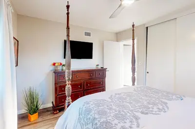 a bedroom with a bed with a dresser and a tv at Dog-Friendly Home Saltwater Pool, Fire Pit, Games in San Diego