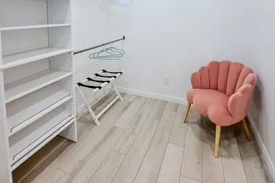a room with a pink chair and a closet at Dog-Friendly Home Saltwater Pool, Fire Pit, Games in San Diego