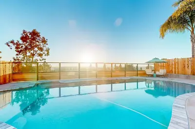 a swimming pool with a fence and blue water at Dog-Friendly Home Saltwater Pool, Fire Pit, Games in San Diego