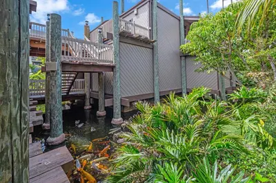 a wooden deck with a koi pond in front of a house at North Coast C106 in Oceanside