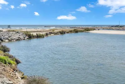 a body of water next to a sandy beach at North Coast C106 in Oceanside