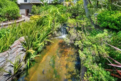 a pond with a waterfall in a garden at North Coast C106 in Oceanside