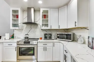 a white kitchen with white cabinets and appliances at North San Diego Retreat with Deck, Fire Pit Table! in Escondido