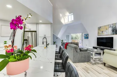 a kitchen and living room with white walls at North San Diego Retreat with Deck, Fire Pit Table! in Escondido