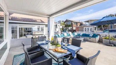 an outdoor patio with a table and chairs at Ocean Breeze Buyout by AvantStay Steps to Beach in Newport Beach