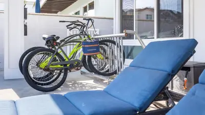 a bike parked on a porch next to a chair at Ocean Breeze I by AvantStay Steps to the Beach in Newport Beach