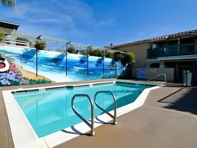 a swimming pool with a mural on the side of a building at Laguna Brisas - A Beach Hotel in Laguna Beach