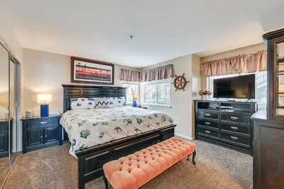 a bedroom with a bed and a television and a bench at Ocean-View Imperial Beach Condo with Community Perks in Imperial Beach