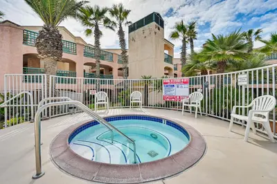 a hot tub with chairs and palm trees and a building at Ocean-View Imperial Beach Condo with Community Perks in Imperial Beach