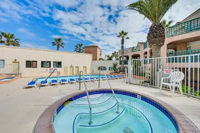 a swimming pool at a resort with a palm tree at Ocean-View Imperial Beach Condo with Community Perks in Imperial Beach