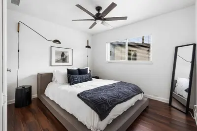 a bedroom with a bed with a ceiling fan at San Diego Chill House with Jacuzzi-Golf-Game Room in San Diego