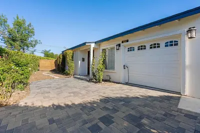 a house with a white garage and a driveway at San Diego Chill House with Jacuzzi-Golf-Game Room in San Diego