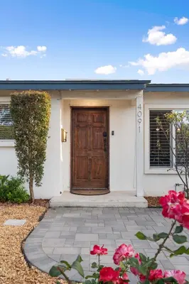 a house with a wooden door and some flowers at San Diego Chill House with Jacuzzi-Golf-Game Room in San Diego