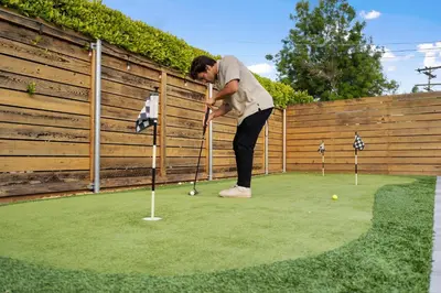 a woman playing golf on a putting green at San Diego Chill House with Jacuzzi-Golf-Game Room in San Diego