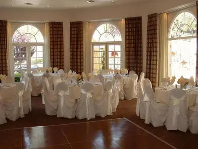 a room with white tables and chairs in a room with windows at Hotel San Diego-Rancho Bernardo in Rancho Bernardo