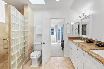 a white bathroom with a toilet and a sink at The Mission Beach VIP- 3 Decks, AC, Steps to Sand! in San Diego