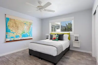a bedroom with a bed with a map on the wall at Pet Friendly Beach Bungalow, Close to Beach in Carlsbad