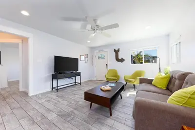 a living room with a couch and a flat screen tv at Pet Friendly Beach Bungalow, Close to Beach in Carlsbad