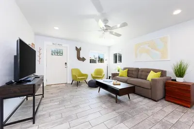 a living room with a couch and a flat screen tv at Pet Friendly Beach Bungalow, Close to Beach in Carlsbad