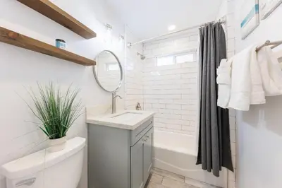 a bathroom with a sink and a tub and a mirror at Pet Friendly Beach Bungalow, Close to Beach in Carlsbad