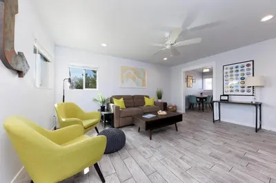 a living room with yellow chairs and a couch at Pet Friendly Beach Bungalow, Close to Beach in Carlsbad