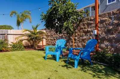two blue chairs sitting on the grass in a yard at Walk to Beach, Outdoor Living, Pet-Friendly! in Carlsbad