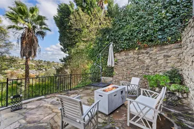 a patio with a table and chairs and a stone wall at Executive Retreat - Renovated - Spacious - Views in La Mesa