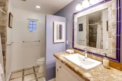 a bathroom with a sink and a toilet and a mirror at Villa Solamar-Sunset Cliffs Spectacular in San Diego