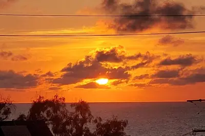 a sunset over the ocean with the sun setting at Villa Solamar-Sunset Cliffs Spectacular in San Diego