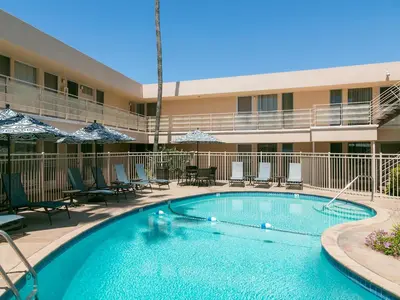 a swimming pool in front of a hotel at La Jolla Riviera Inn in San Diego