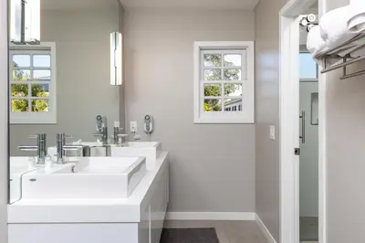 a white bathroom with two sinks and two mirrors at Cypress Cabana Chateau Luxury Vacation Villa in San Diego