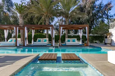 a swimming pool with chairs and a gazebo at Cypress Cabana Chateau Luxury Vacation Villa in San Diego